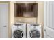 Functional laundry room with appliances, storage cabinets, and white walls at 10057 Des Moines St, Parker, CO 80134