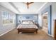 Serene main bedroom with tray ceilings, a ceiling fan, large windows, and an ensuite bathroom at 10057 Des Moines St, Parker, CO 80134