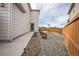 Side view of backyard featuring gravel landscaping, modern fencing, and a concrete patio for outdoor enjoyment at 11677 Park South Ln, Parker, CO 80138