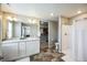 This bathroom has a double sink, large mirror, walk in shower, and open access to a closet at 11677 Park South Ln, Parker, CO 80138