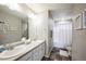 This bathroom has a double sink vanity and a walk-in shower with white tile at 11677 Park South Ln, Parker, CO 80138