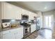 This kitchen features stainless appliances, granite counters, white cabinets, and modern fixtures at 11677 Park South Ln, Parker, CO 80138