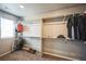 This walk-in closet has carpeted floors, a small window, and rods for hanging clothing at 11677 Park South Ln, Parker, CO 80138