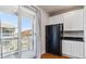 Kitchen adjacent to sunny balcony with modern cabinets and black refrigerator at 9351 Amison Cir # 104, Parker, CO 80134