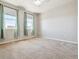Bright bedroom featuring neutral carpet, light walls, and two windows with elegant, light-green curtains at 9351 Amison Cir # 104, Parker, CO 80134