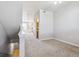 Upstairs hallway with neutral walls and carpets leading to bathroom and front door at 9351 Amison Cir # 104, Parker, CO 80134