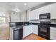Modern kitchen with black appliances, white cabinets, and hardwood flooring at 9351 Amison Cir # 104, Parker, CO 80134