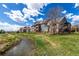 Exterior view of blue and tan apartment building along a gently flowing stream and manicured lawn at 804 Summer Hawk Dr # 303, Longmont, CO 80504