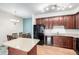 Open-concept kitchen includes an island, stainless-steel refrigerator, and a dining area at 804 Summer Hawk Dr # 303, Longmont, CO 80504