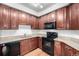 Updated kitchen features wood cabinets, stone countertops, and modern black appliances at 804 Summer Hawk Dr # 303, Longmont, CO 80504