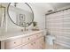 Modern bathroom features a pink vanity, gold hardware, round mirror, and walk in shower at 7050 W Cedar Ave # 108, Lakewood, CO 80226