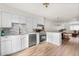 Bright kitchen featuring white cabinets, stainless steel appliances and wood-look flooring at 7050 W Cedar Ave # 108, Lakewood, CO 80226