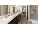 Double vanity bathroom with a walk-in shower and view of bedroom at 6916 Crestop Pl # A, Parker, CO 80138