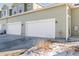 Attached garages with white doors and exterior lighting at 6916 Crestop Pl # A, Parker, CO 80138