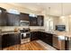 Spacious kitchen with stainless steel appliances and dark wood cabinets at 6916 Crestop Pl # A, Parker, CO 80138