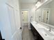 Bathroom with a double sink vanity, large mirror, and a view into a shower/tub combo room at 6023 Chester Way, Denver, CO 80238