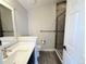 Modern bathroom featuring a glass-enclosed shower, single sink and mirror, and neutral color palette at 6023 Chester Way, Denver, CO 80238