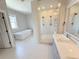 Modern bathroom with a freestanding tub, large glass-enclosed shower, and dual sink vanity at 6023 Chester Way, Denver, CO 80238
