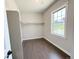 Walk-in closet with hardwood floors, rod for hanging clothes, and a window for natural light at 6023 Chester Way, Denver, CO 80238