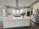 Modern kitchen with a large center island, stainless steel appliances, and sleek white cabinetry at 6023 Chester Way, Denver, CO 80238