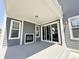 Covered patio with gray decking, fireplace, and large sliding glass doors for indoor/outdoor living at 6023 Chester Way, Denver, CO 80238