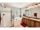 Bathroom with a shower, tub, tile accents, and double vanity with wood cabinets at 10677 Cedarcrest Cir, Highlands Ranch, CO 80130