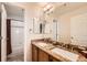 Well-lit bathroom with a double vanity, granite countertop, and shower-tub combo at 10677 Cedarcrest Cir, Highlands Ranch, CO 80130