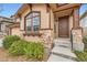 Close-up of a home's front entrance, featuring a wood door, stone accents, and a large window at 10677 Cedarcrest Cir, Highlands Ranch, CO 80130