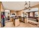 Well-lit kitchen with wood cabinetry, black countertops, stainless steel appliances, and an open design flowing into the living area at 10677 Cedarcrest Cir, Highlands Ranch, CO 80130