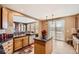 An open kitchen with an island, tile floors, wood cabinets, and stainless steel appliances at 10677 Cedarcrest Cir, Highlands Ranch, CO 80130