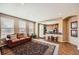 Inviting living room with a leather sofa, large rug, and an open view into the kitchen, creating a warm and connected living space at 10677 Cedarcrest Cir, Highlands Ranch, CO 80130
