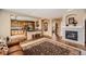 Open-concept living area flowing into the kitchen, featuring a fireplace, tiled flooring, and warm, inviting lighting at 10677 Cedarcrest Cir, Highlands Ranch, CO 80130