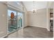 Dining area with wood floors, a modern chandelier and sliding door to balcony at 3337 S Monaco Pkwy # C, Denver, CO 80222