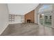 Living room with wood floors, exposed shelving, brick fireplace, and sliding door to balcony at 3337 S Monaco Pkwy # C, Denver, CO 80222
