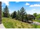 Backyard view featuring tiered garden, manicured lawn, fencing, and mature trees, great for outdoor activities at 24022 E Jamison Dr, Aurora, CO 80016
