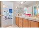 Bathroom with dual sinks, bright natural light from adjacent bedroom, and a large countertop at 24022 E Jamison Dr, Aurora, CO 80016