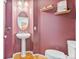 Powder room featuring a pedestal sink, wood floors, and a decorative mirror at 24022 E Jamison Dr, Aurora, CO 80016