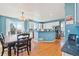 Open concept kitchen featuring white cabinets, blue walls, stainless appliances, and hardwood floors at 24022 E Jamison Dr, Aurora, CO 80016