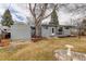 Backyard with a well-maintained lawn and mature tree providing shade, plus a gray home exterior at 5271 S Logan St, Littleton, CO 80121