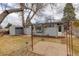 Backyard featuring a small patio area, grass, and a view of the gray home with well-kept lawn and shed at 5271 S Logan St, Littleton, CO 80121