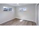 Bright bedroom featuring neutral walls, wood floors, and ample natural light from two large windows at 5271 S Logan St, Littleton, CO 80121