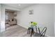 Bright dining area features a modern glass table, wood-look flooring, and an open layout leading to the living room at 5271 S Logan St, Littleton, CO 80121