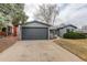 Exterior view of the home featuring a large gray garage door and well-maintained front yard at 5271 S Logan St, Littleton, CO 80121