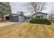 Exterior of the home featuring a large garage door, well-maintained yard, and tasteful landscaping at 5271 S Logan St, Littleton, CO 80121