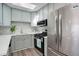 Well-lit kitchen featuring stainless steel appliances, a sleek tile backsplash, and ample counter space at 5271 S Logan St, Littleton, CO 80121