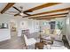 Open-concept living room features exposed beams, stylish furniture, and wood-look flooring that brings warmth to the space at 5271 S Logan St, Littleton, CO 80121
