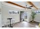 Cozy living room features wood-look flooring, exposed beams, and a stylish black door at 5271 S Logan St, Littleton, CO 80121