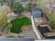 An aerial view of the backyard featuring a greenhouse, storage shed, and green lawn at 835 S Shoshone St, Denver, CO 80223