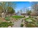 Landscaped backyard featuring a greenhouse, storage shed, and gravel walkway at 835 S Shoshone St, Denver, CO 80223