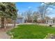 The backyard features green lawn, a storage shed, and mature trees for shade at 835 S Shoshone St, Denver, CO 80223